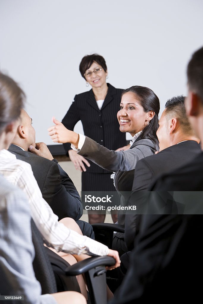 group of businesspeople, focus on woman in audience speaking